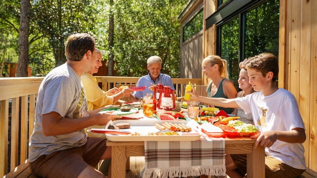 Familia come em mesa do lado de fora da cabine do Fort Wilderness Resort, hotel do complexo de Walt Disney World Resort