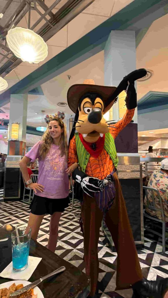 Mulher posa com o Pateta durante refeição no restaurante Hollywood & Vine no Hollywood Studios que oferece experiência com personagens no Café da manhã, almoço e jantar