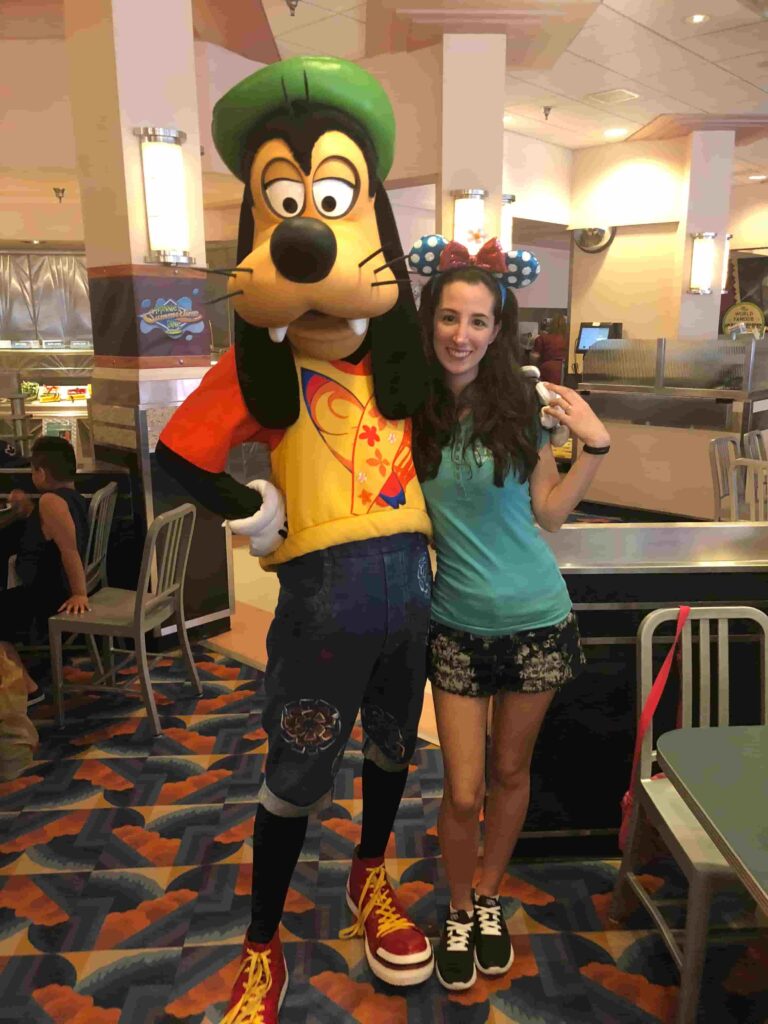 Mulher posa com o Pateta durante refeição no restaurante Hollywood & Vine no Hollywood Studios que oferece experiência com personagens no Café da manhã, almoço e jantar