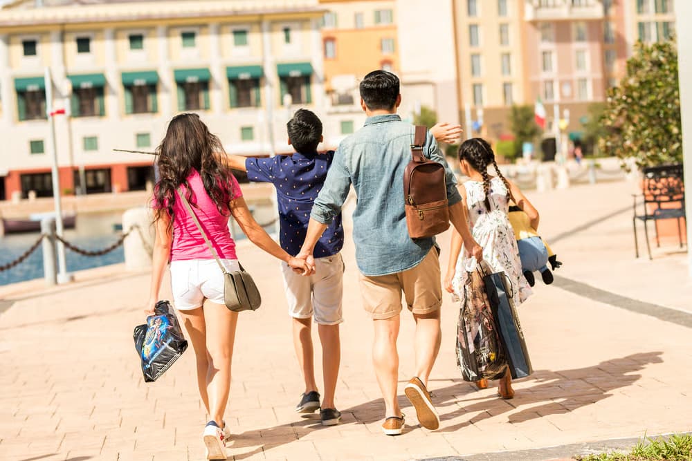 Família retorna feliz ao Portofino Bay Hotel na Universal Orlando após um dia de parque com Express Pass, um dos benefícios do hotel