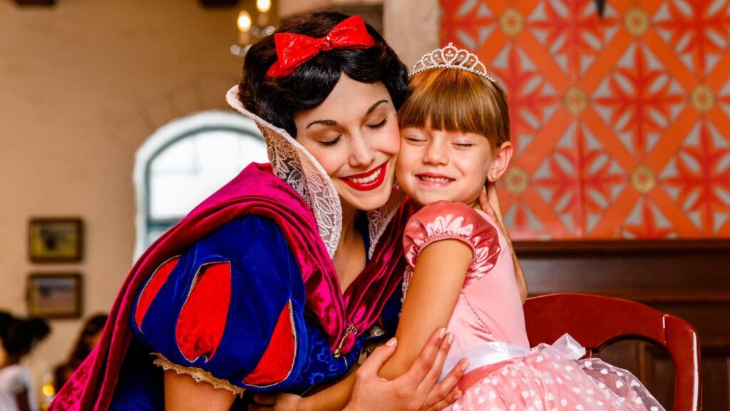 Menininha recebe abraço carinhoso da princesa Branca de Neve no restaurante Akershus no Epcot, parque temático de Walt Disney World