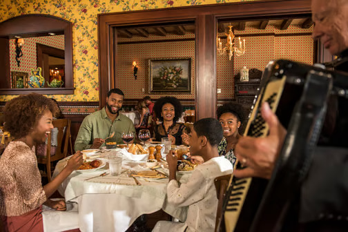 Família se diverte ao jantar com música ao vivo em um dos restaurantes do Portofino Bay Hotel na Universal Orlando um dos hotéis de luxo com direito ao Express