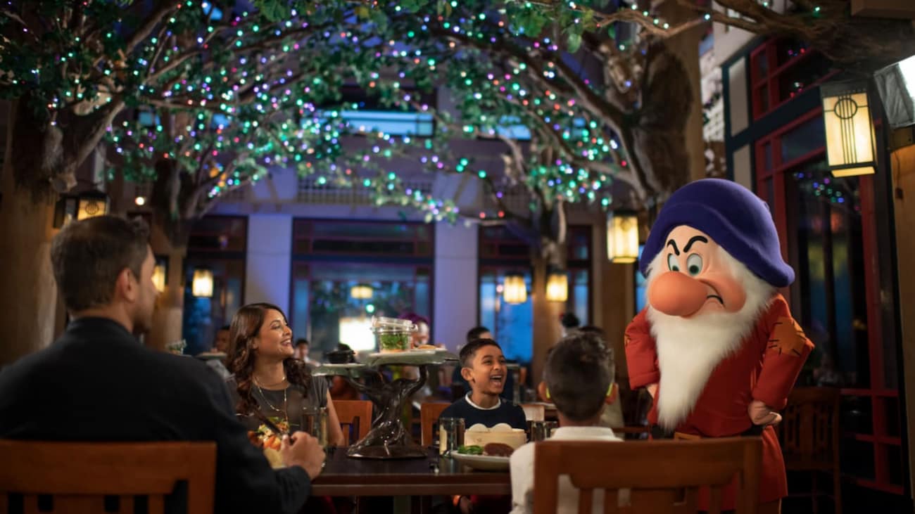 Zangado interage com visitantes que jantam no Storybook Dining at Artist Point, restaurante com personagens no Wilderness Lodge que conta com Zangado, Dunga, Branca de Neve e Rainha Má