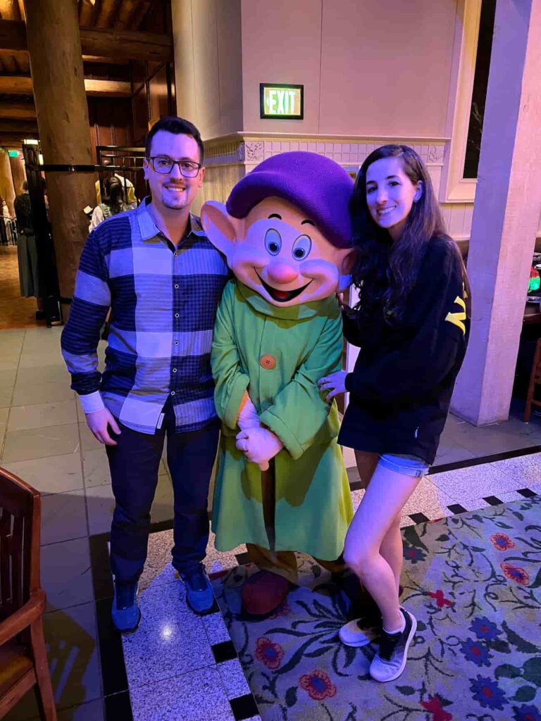 Dunga tira foto com visitantes no Storybook Dining at Artist Point, restaurante com personagens no Wilderness Lodge que conta com Zangado, Dunga, Branca de Neve e Rainha Má