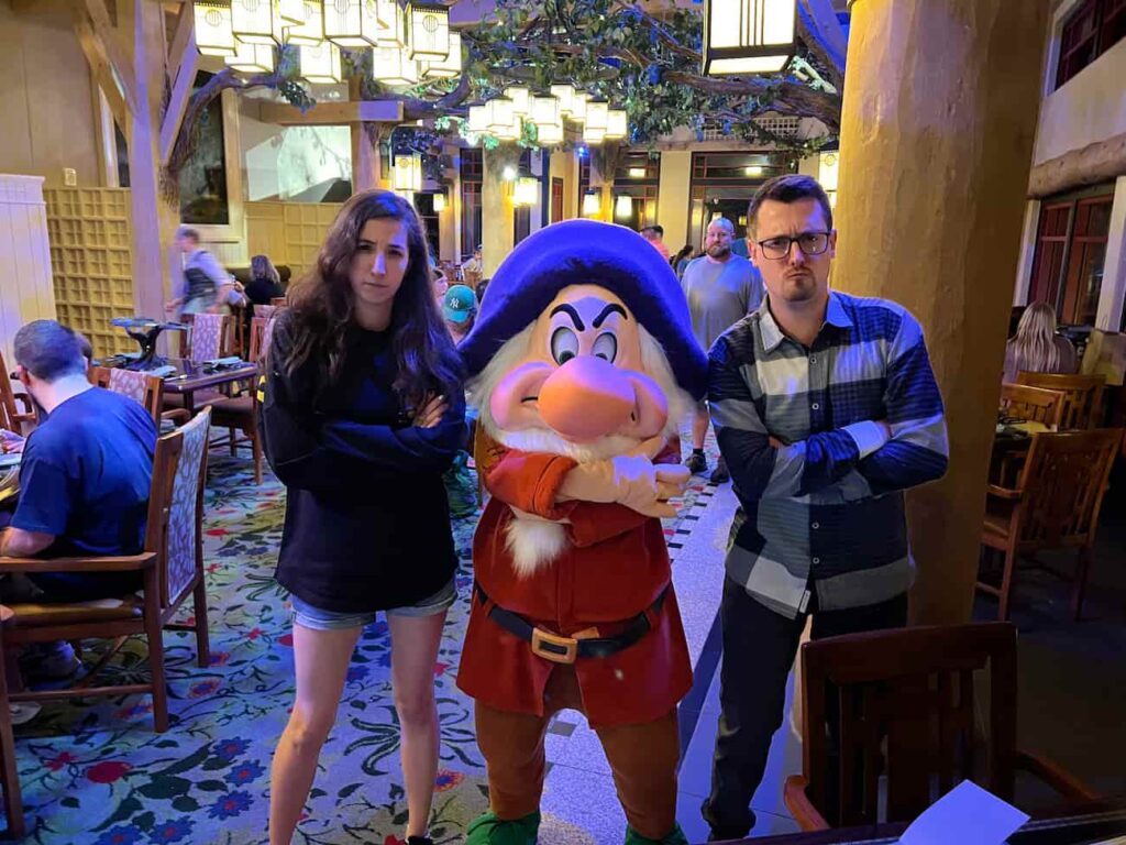 Zangado posa para fotos com visitantes no Storybook Dining at Artist Point, restaurante com personagens no Wilderness Lodge que conta com Zangado, Dunga, Branca de Neve e Rainha Má