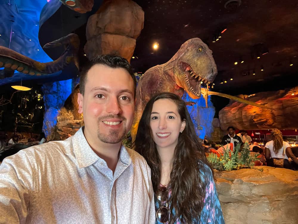 Casal posa em frente a um T-Rex dentro do restaurante T-Rex em Disney Springs