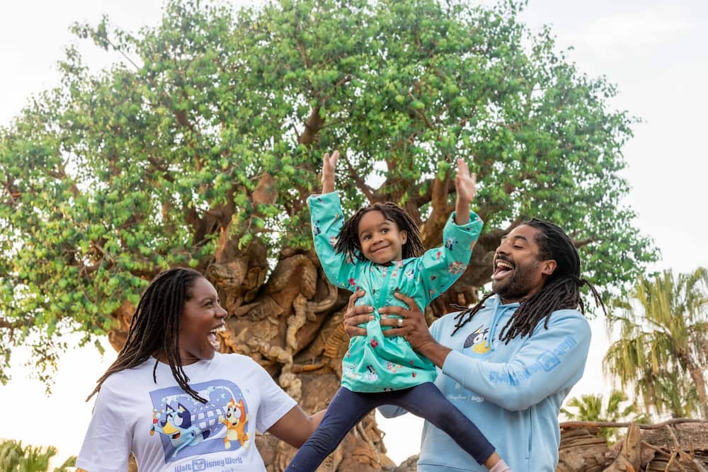 Pais felizes com seu filho em frente a Arvore da Vida no Animal Kingdom da Disney World