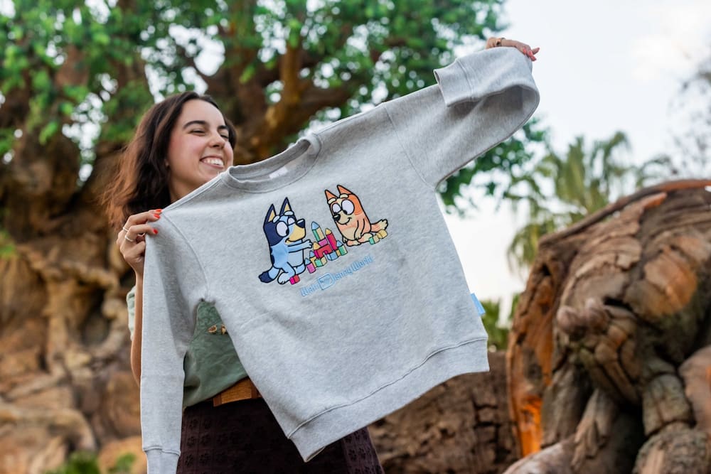 Mulher segura moletom do Bluey e Bingo que são as novas estrelas do parque Disney's Animal Kingdom em Orlando