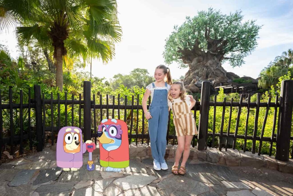 Meninas posam no Animal Kingdom com a Árvore da Vida ao fundo e Magic Shot do Bluey e Bingo