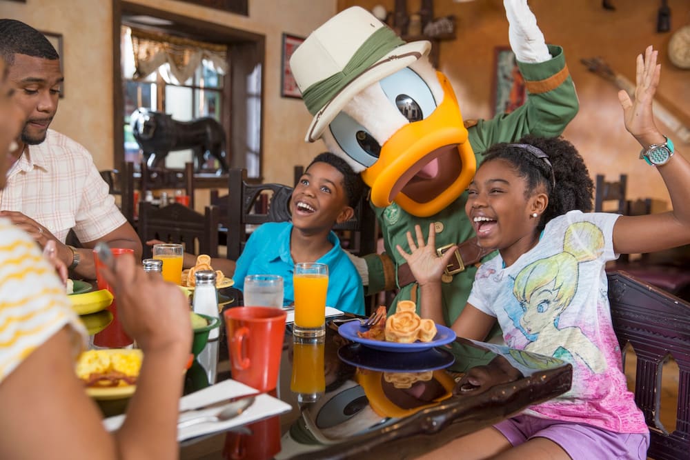 Família posa para foto com Pato Donald enquanto se divertem durante refeição com personagens no Tusker House localizado no Animal Kingdm