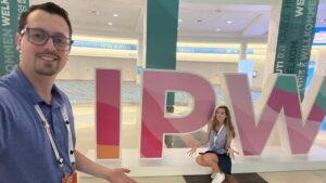 Casal posa com letreiro da IPW, maior evento de turismo dos EUA, que visa promover destinos dos Estados Unidos para visitantes de todo o mundo, dentro do centro de convenções