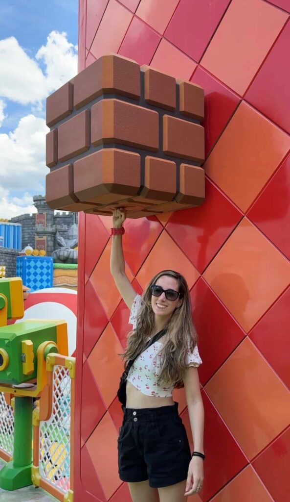 Mulher coleta moedas com sua power up band em Super Nintendo World no Epic Universe em Orlando