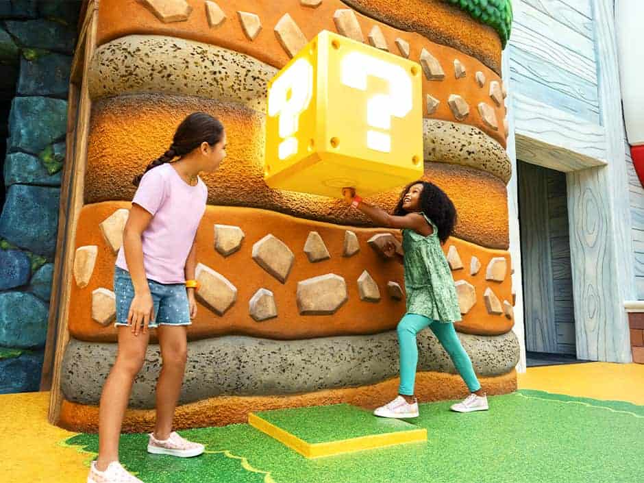 Mulheres coletam moedas em Nintendo World com suas Power Up Bands