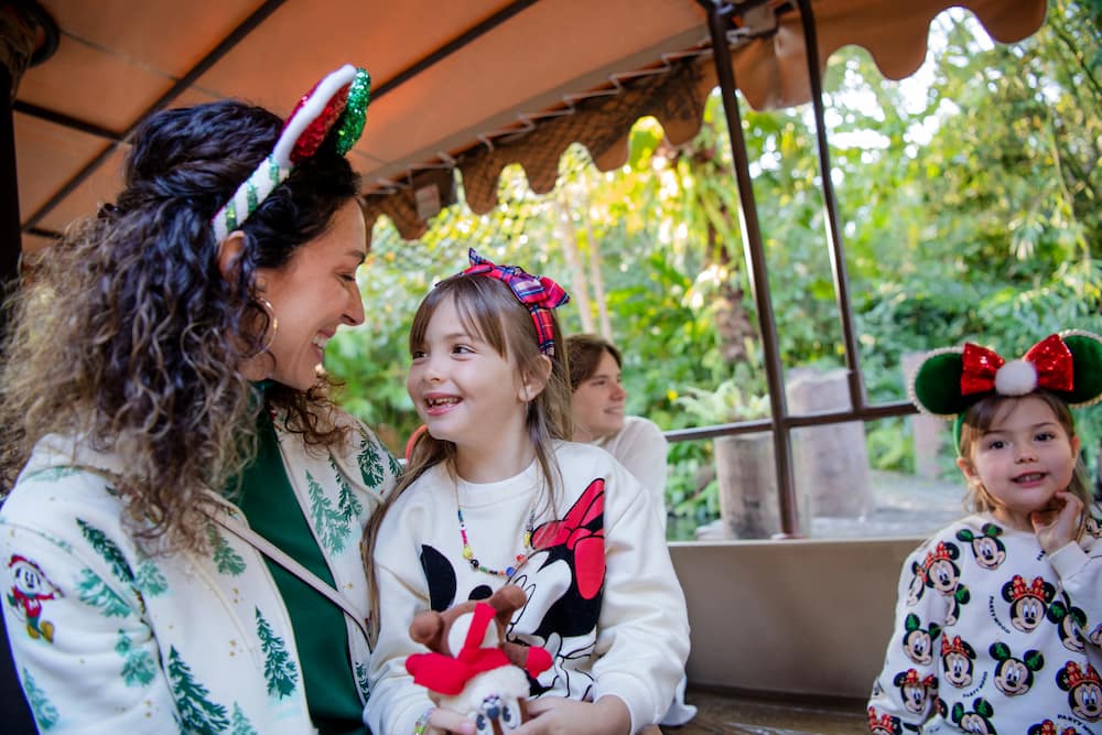 Mãe e filha se divertem com outros visitantes na Jingle Cruise, a versão natalina da clássica atração Jungle Cruise no Magic Kingdom Park