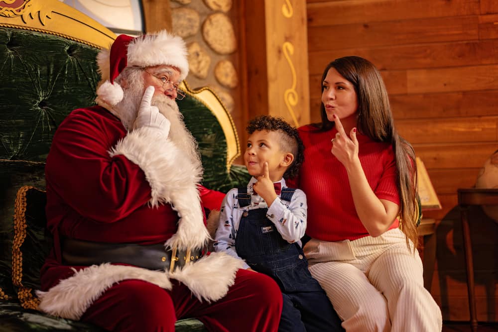 Menino com sua mãe encontram o Papai Noel em Disney Springs durante o período de natal
