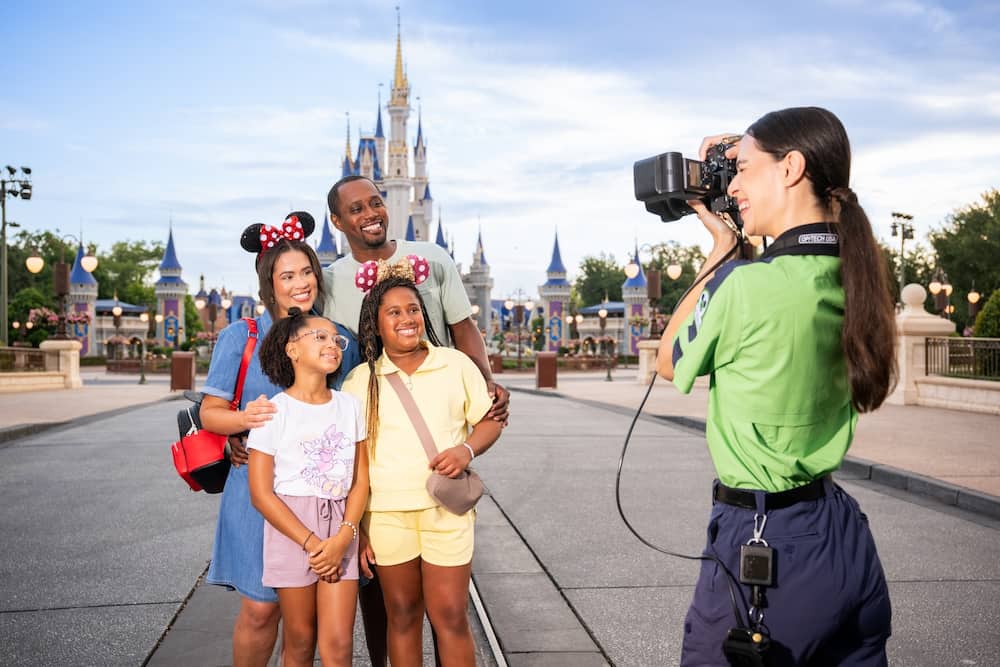 Fotógrafa do Disney Photopass tira foto de família em frente ao castelo da Cinderela no Magic Kingdom Park