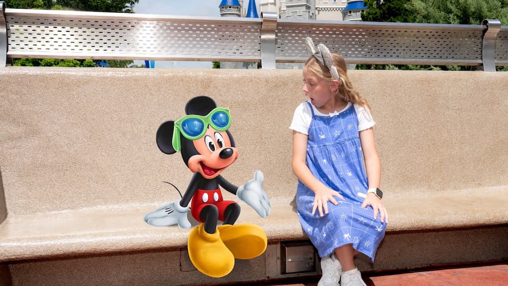 Menininha posa surpresa olhando para o Mickey em uma Magic Shot do Memory Maker no Magic Kingdom Park