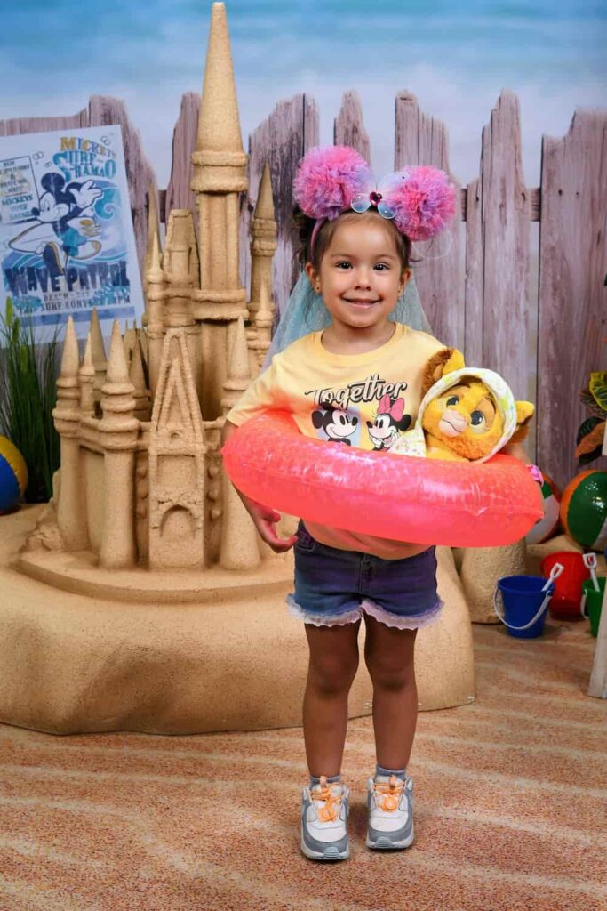 Menininha posa com bóia em cenário do Disney Photopass Studio no Disney Springs