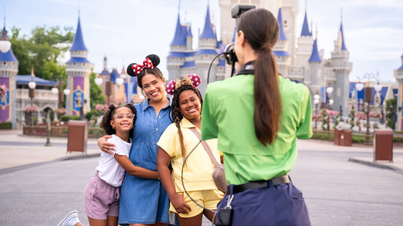 Fotógrafa do Disney Photopass tira foto de família em frente ao castelo da Cinderela no Magic Kingdom Park