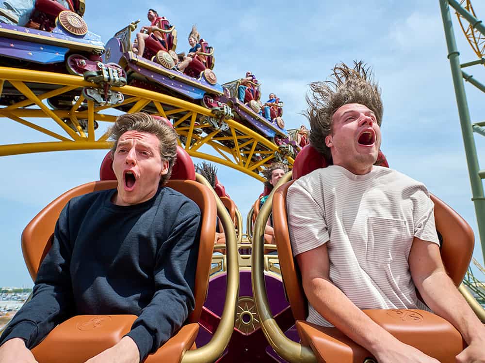 Amigos gritam com a emoção e adrenalina ao andar na montanha russa Stardust Racers no Universal Epic Universe