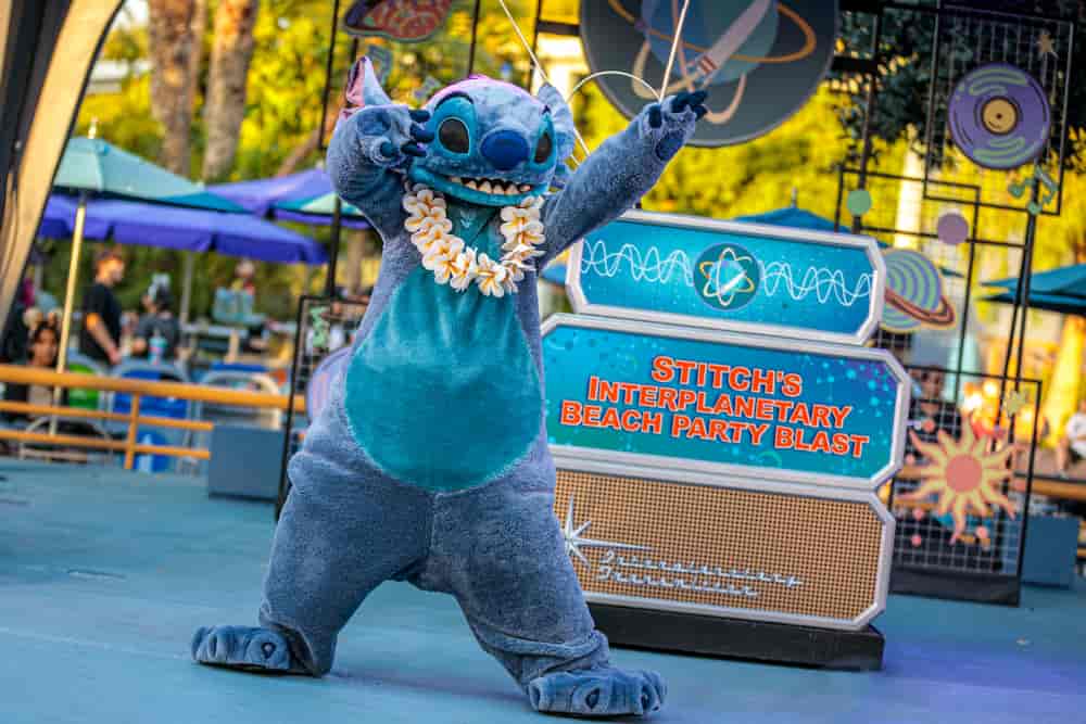 Stitch com colar havaiano aparece para encontrar os visitantes durante o Dia D23 na Disneyland