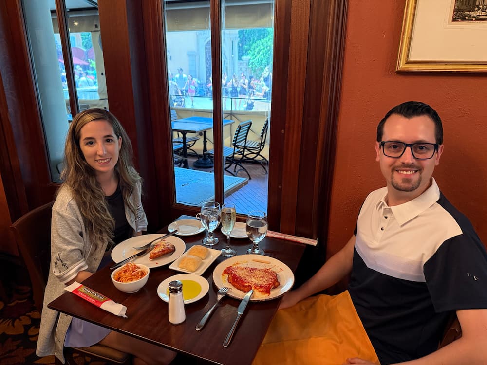 Casal posa feliz ao almoçar no Tutto Italia, restaurante italiano do parque temático Epcot na Disney
