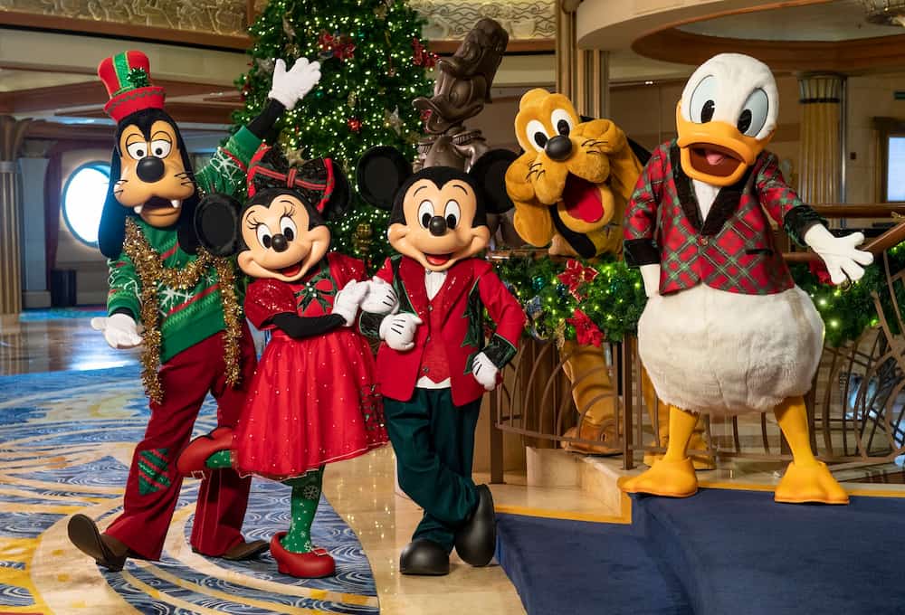 Pateta, Minnie, Mickey, Pluto e Donald com trajes de natal recepcionam visitantes durante cruzeiros de natal da Disney