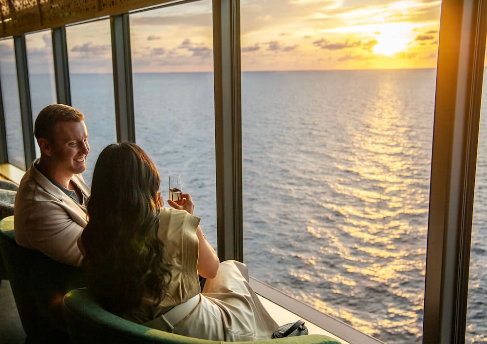 Casal assiste ao por do sol dentro do navio da Disney Cruise Line