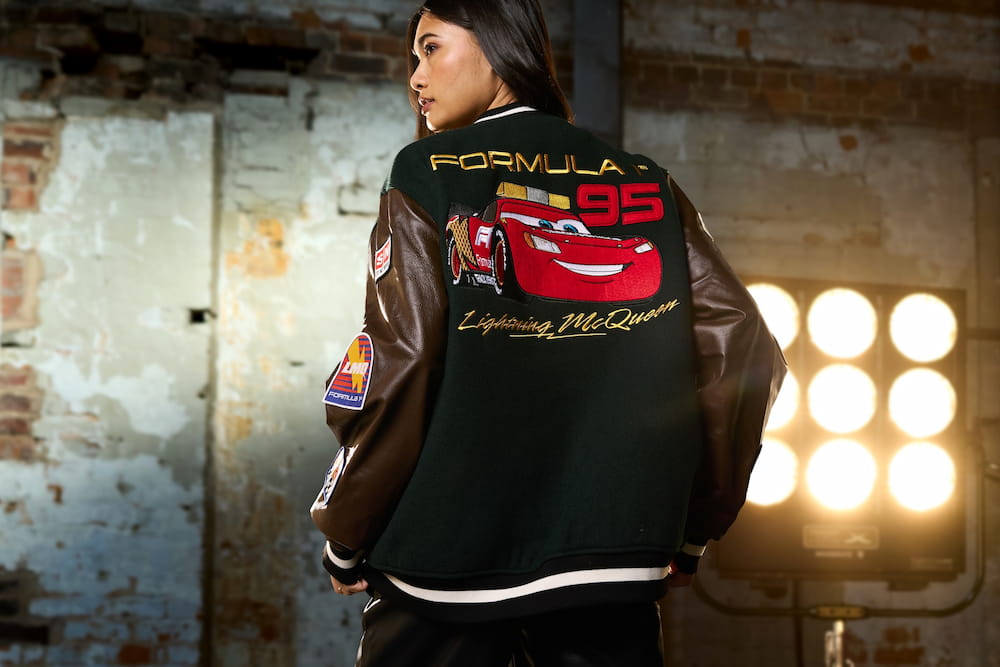 Mulher posa estilosa usando roupa de fórmula 1 com o Lightning Mcqueen