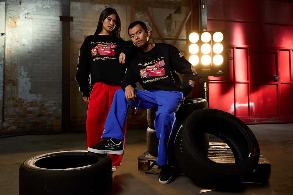 Casal posa estiloso usando roupa de fórmula 1 com o Lightning Mcqueen