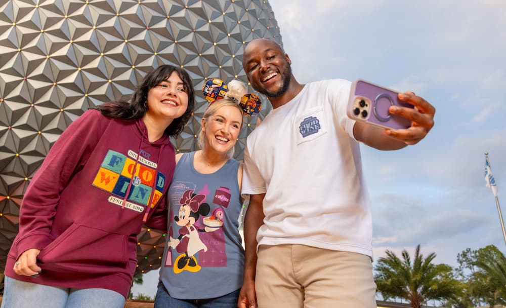 Amigos posam felizes enquanto tiram uma selfie em frente a Spaceship Earth no Epcot durante o Food and Wine Festival