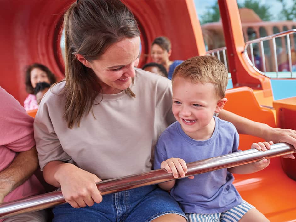 Mãe e filho se divertem em montanha russa infantil no Universal Kids Resort em Frisco no Texas