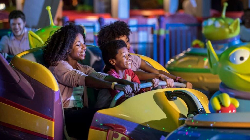 Mãe e filhos se divertem em Alien Swirling Saucers em Walt Disney World Resort
