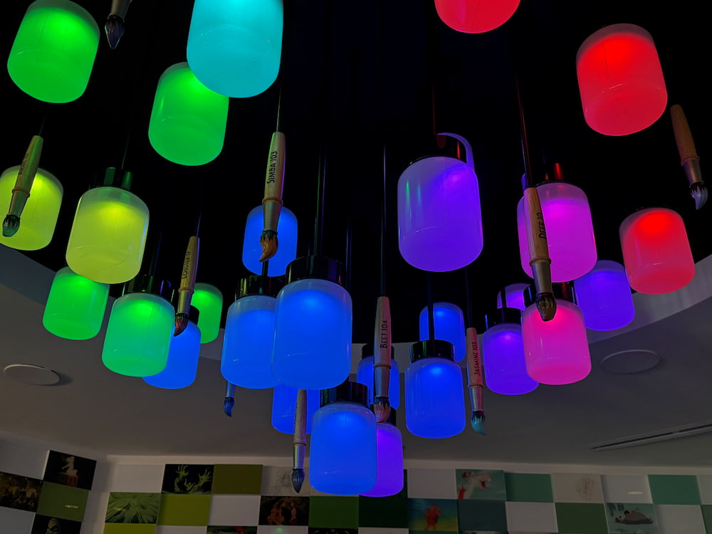 Luminárias coloridas que sugerem baldes de tinta junto a pincéis iluminam e enfeitam a nova área Magic of Disney Animation no Hollywood Studios em Walt Disney World Resort