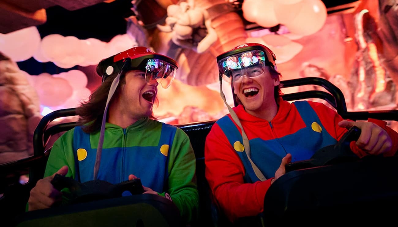 Amigos com roupa de Mario e Luigi se divertem ao pilotar kart durante a atração Mario Kart Bowser's Challenge no Epic Universe da Universal Studios Florida em Orlando