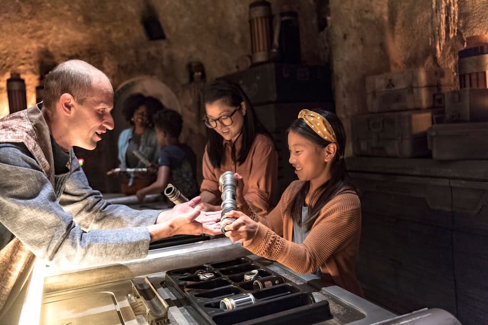 Menina recebe peças para construir seu sabre de luz em Galaxy's Edge no Disney's Hollywood Studios