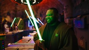 Homem admira feliz o seu sabre de luz construído por ele no Savi's Workshop dentro do parques temático Disney's Hollywood Studios em Walt Disney World Resort em Orlando