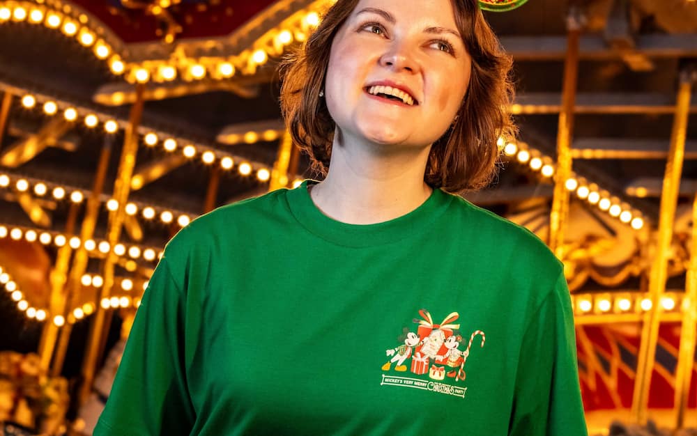 Mulher usando camiseta de merchandising especial da festa de natal do Magic Kingdom Mickey's Very Merry Christmas Party 2026