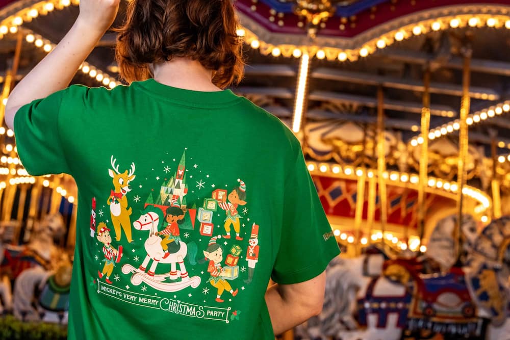 Mulher usando camiseta de merchandising especial da festa de natal do Magic Kingdom Mickey's Very Merry Christmas Party 2026