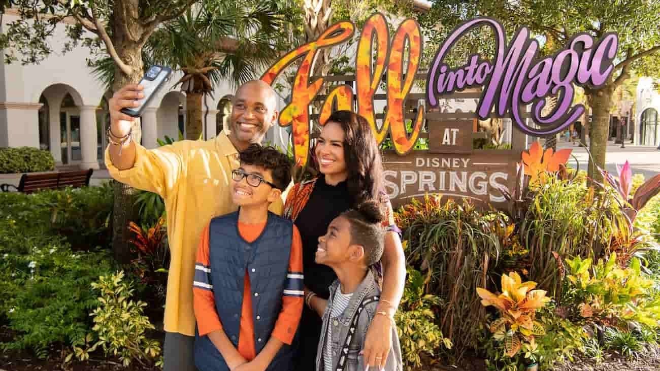Família posa feliz para selfie em Disney Springs durante o outono com decoração especial de Halloween