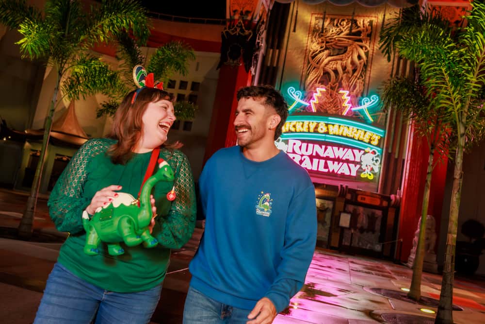 Homen e mulher usam merchandising especial da festa de natal do Hollywood Studios, a Jollywood Nights 2026